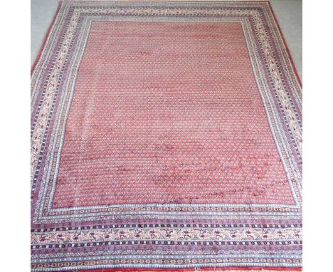 A Persian arak carpet, having a red ground, within multiple borders, 355 x 272cmOverall condition is complete and undamaged. 
