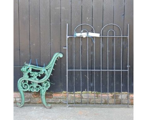 A black painted iron gate, 126 x 97cm, together with a pair of green painted metal bench ends (3)