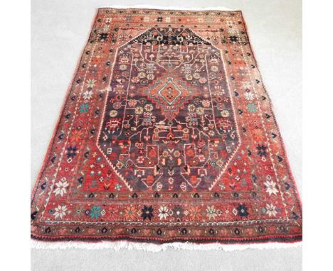 A Persian carpet, with foliate motifs, on a red ground 220 x 141cm