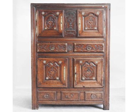 An 18th century continental carved walnut sacristy cupboard, decorated throughout with hearts, crosses and foliate designs, c