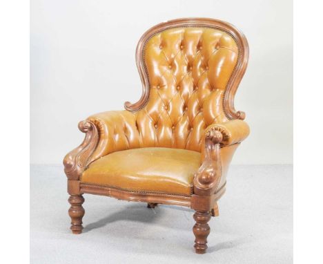 A Victorian tan upholstered button back armchair, on cabriole legs