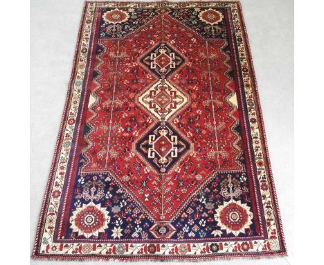A Persian qashgai carpet, with a row of three central medallions, 280 x 185cm