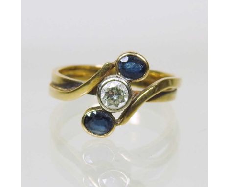 An 18 carat gold sapphire and diamond ring, of crossover design, the central diamond flanked by collet set sapphires, 5.1g, s