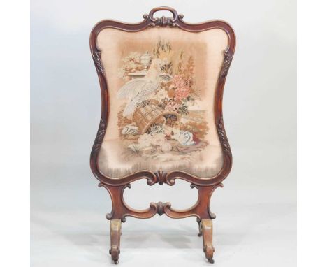 A 19th century carved mahogany firescreen, inset with a woolwork panel, 114 x 66cm
