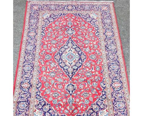 A Persian Kashan carpet, with all over foliate designs, on a red field, 307 x 200cm