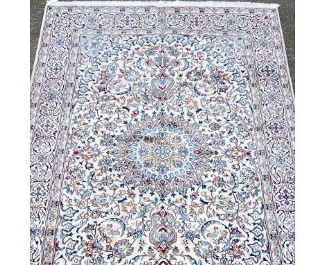 A Persian Nain carpet, with a central medallion and scrolling motifs, on a cream ground, 300 x 200cm