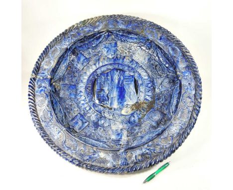 An imposing blue glazed Castle Hedingham pottery charger, decorated in relief with Heraldic devices, by Edward Bingham, inscr