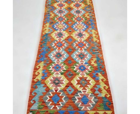 A Persian kilim runner, with two rows of medallions, 242 x 80cm