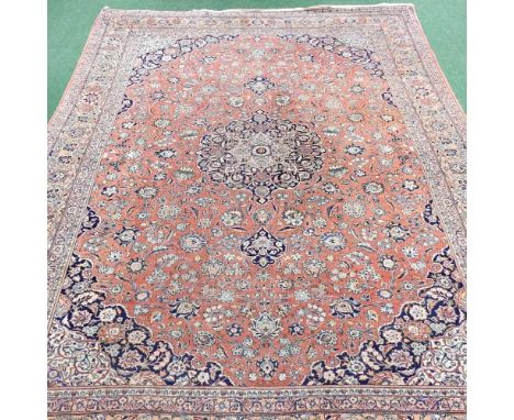 A large Persian carpet, early to mid 20th century, with all over floral designs, on a red ground, within multiple borders, 37