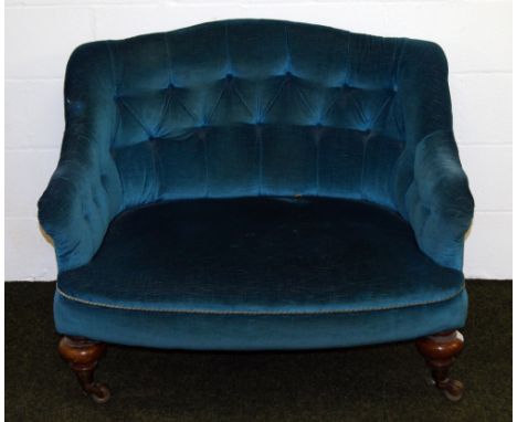 A Victorian upholstered button-back lovers' chair, raised on turned mahogany supports with castors
