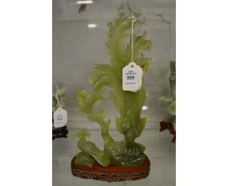 A Chinese carved jade group of hardwood stand.