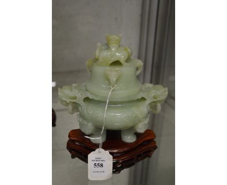 A Chinese carved jade koro and cover on hardwood stand.