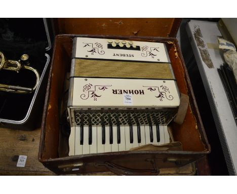 A cased Hohner student accordion.