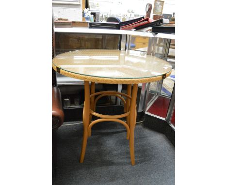 A modern lloyd loom circular glass top bistro table.