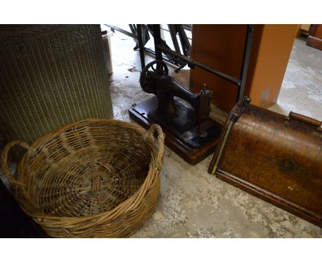 A basket, lloyd loom linen basket and a sewing machine.