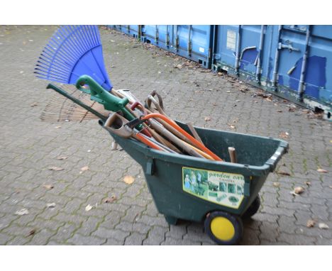 A wheelbarrow containing a quantity of gardening tools.
