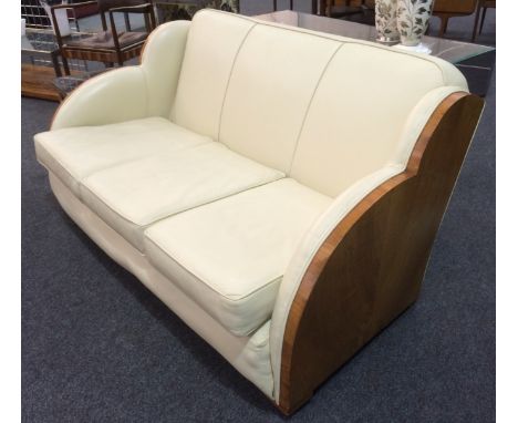 Unknown - An Art Deco three seat sofa of cloud form, with exposed walnut veneered side panels. 