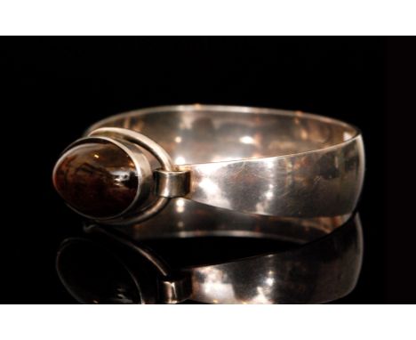 Nils Erik From - A Danish sterling silver bangle of tapering oval outline, the clasp formed of an oval loop and centred by a 