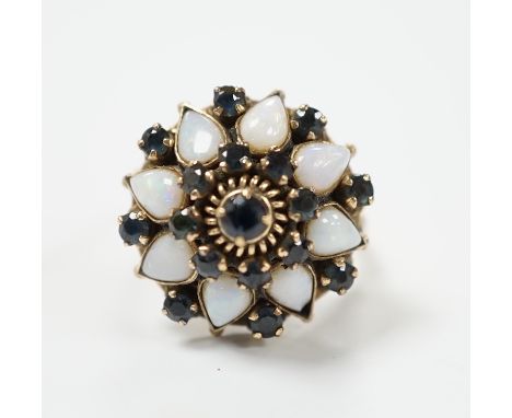 An 18k, white opal and sapphire set domed cluster dress ring, size O, gross weight 6.6 grams.