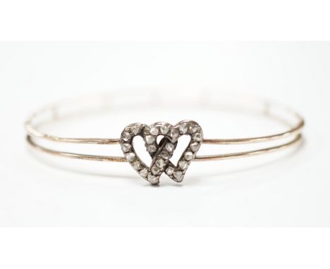 A late Victorian yellow metal and rose cut diamond set twin hearts bangle, gross weight 6.8 grams.