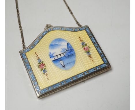 An early to mid 20th century continental white metal and polychrome enamelled purse shaped compact, with chain, decorated wit
