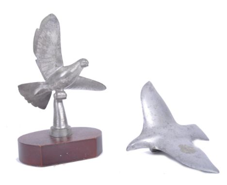 Two vintage pewter / aluminium car mascots, being a c1920s / 1930s dove with outstretched wings atop a C scroll perch mounted