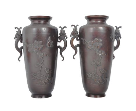 A pair of twin handled Japanese 19th century Meiji period bronze vases. Cast with bird and foliage relief decoration to each 