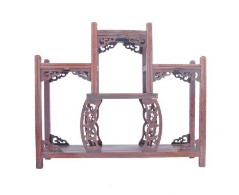 A 20th century Chinese Oriental hardwood four tiers display stand. The stand having four top tiers over a bottom full length 