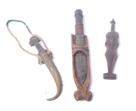 An assorted collection of tribal daggers. The first of wooden naive human form with arrow finial &amp; metal blade, the secon