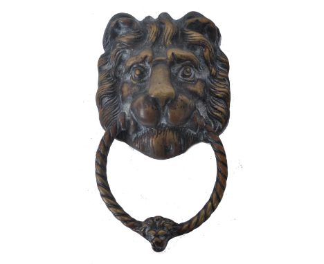 Antique 19th century brass door knocker / handle formed as the face of a lion, clutching in its maw the twisted knocker, with