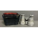 A pair of cased opera glasses with an ornate white metal floral relief case AF