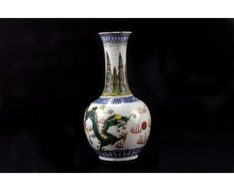 A late 18th century Chinese porcelain bottle vase, decorated with dragons pursuing the pearl of wisdom in famille vert enamel