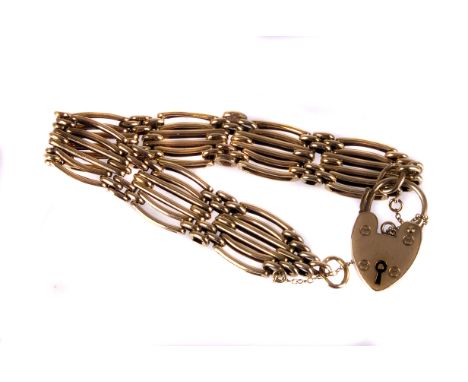 A 9ct gold gate link bracelet, having long and short bar links united by a heart shaped padlock clasp and safety chain, appro