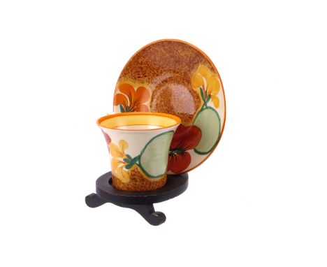 A Clarice Cliff Nasturtium pattern cup and saucer, of Art Deco form, and from the Bizarre range for Newport Pottery (2) 