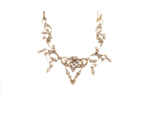 A pretty Victorian 15ct gold and seed pearl fringe necklace, the oranate pierced scroll mounts set with white pearls on a fin