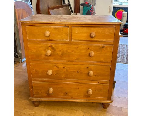 A modern pine chest of drawers, two short over three long drawers with bun handles, raised on turned supports, W95, H102, D46