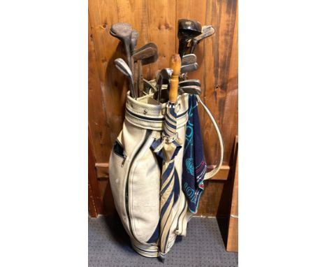 A selection of vintage and modern golf clubs with golf bag. 