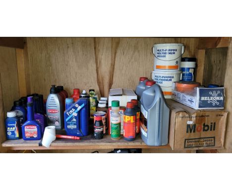 A shelf of unused motor oils and fluids to include two 5L 5W-30 engine oil bottles, Mobil break and clutch fluid and others. 