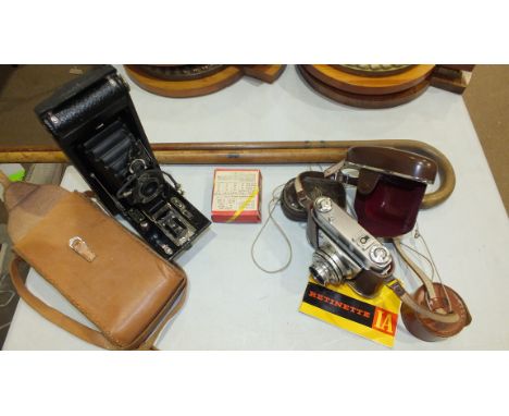 A Kodak Retinetta 1A 35mm camera, a Weston light meter, a Kodak folding camera and two walking sticks.