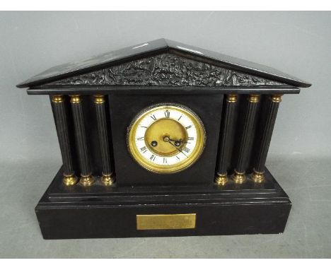 A mantel clock of architectural form with pendulum.
