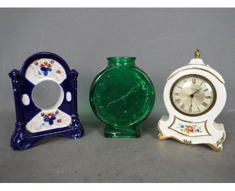 A Smiths Empire Alarmette pottery cased alarm clock, the case having floral decoration on a white background, together with a