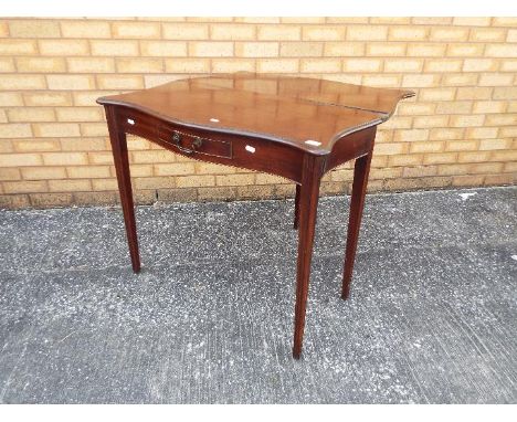 A mahogany fold over, serpentine card table on tapered supports, approximately 72 cm x 87 cm x 86 cm (when opened).