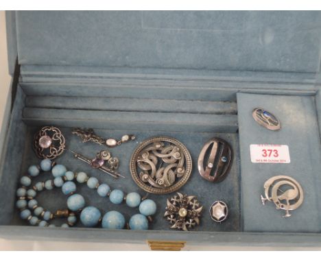 A jewellery box containing a selection of white metal and HM silver brooches including Celtic, enamelled and Scandinavian sty