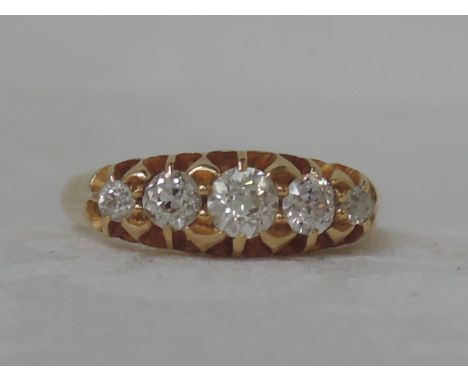 An Edwardian ladies five stone graduated diamond dress ring in a raised gallery setting on an 18ct gold loop, Chester hallmar