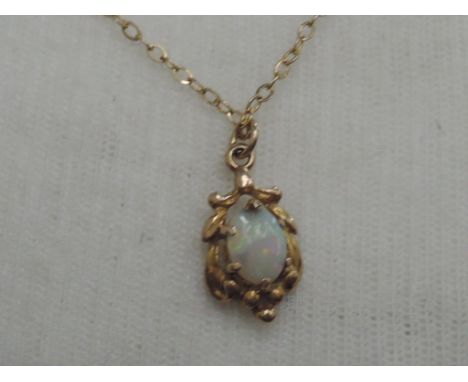 An opal pendant in a decorative 9ct gold mount on a 9ct gold chain