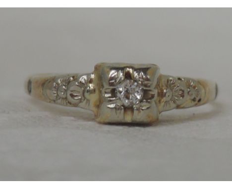 A ladies diamond solitaire ring having a moulded floral mount on a yellow metal loop stamped 15ct, approx 1.6g