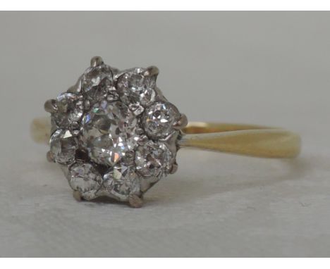 A ladies dress ring having a diamond daisy cluster, approx .75ct in a pave setting on a yellow metal loop stamped 18ct, size 