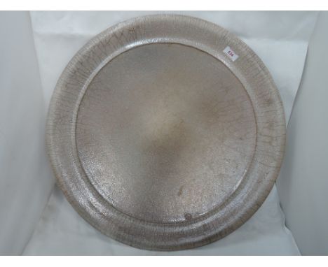 A Studio pottery charger of buff and grey mottled design stamp JD, possibly John Davies