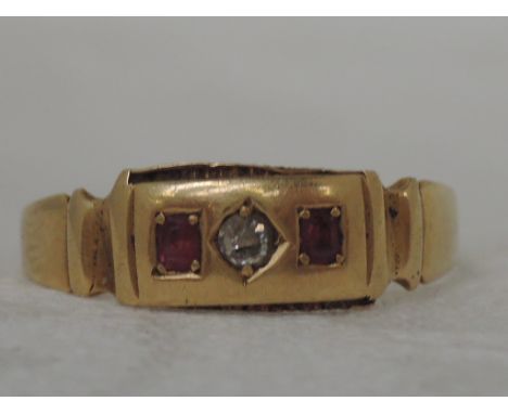 A ladies band ring set with two rubies and a diamond on an 18ct gold loop,  approx 2.3g