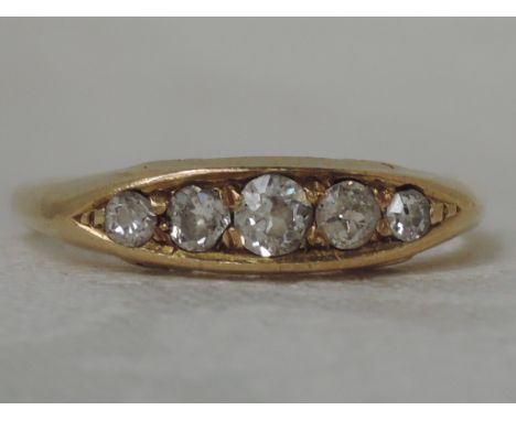 A ladies dress ring having 5 graduated diamonds, (approx .25ct) in a moulded gallery mount on a yellow metal loop stamped 18c